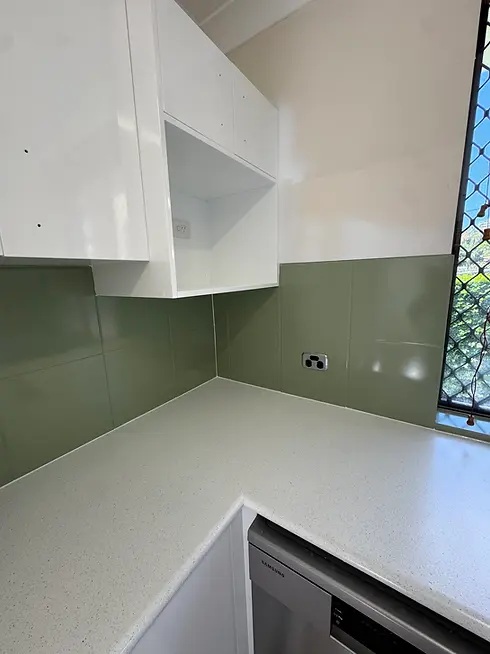 Splashback resurfaced in custom sage blend, cabinetry in white and benchtop in a stone-look finish