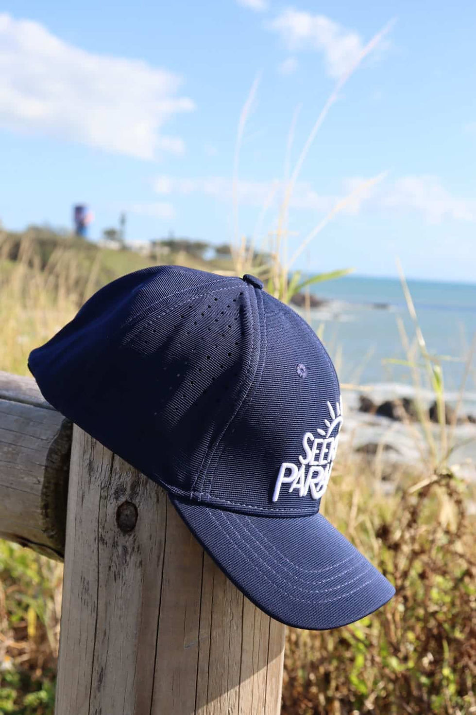 Thumbnail: Side view of navy sports cap with white Seeking Paradise Logo