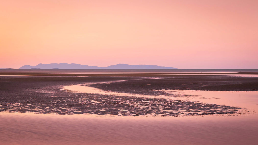 Low tide at a beach with an orange haze