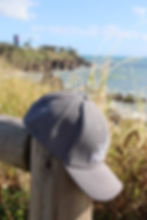 Thumbnail: Side view of grey sports cap with white Seeking Paradise Logo