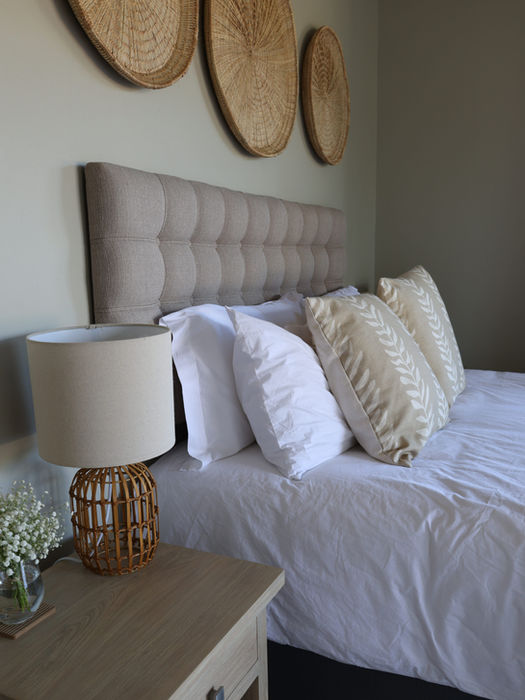 Comfortable main bedroom with a queen sized bed and natural decor