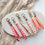 Thumbnail: Gouden en zilveren hangers met gekleurde lintjes