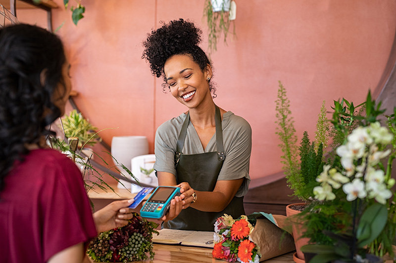 Woman taking a payment in her shop