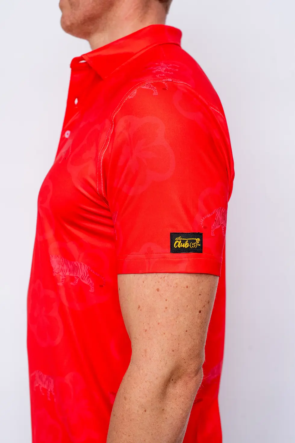 Thumbnail: Red polo shirt sleeve with black and gold label
