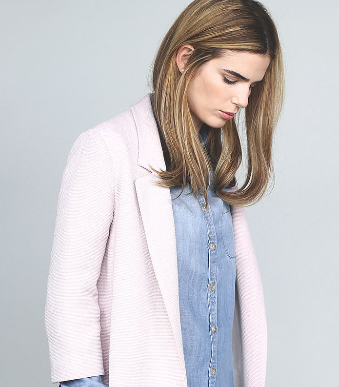 Woman wearing a perfectly fitted jacket, showcasing the precise tailoring skills of Alteration Boutique.