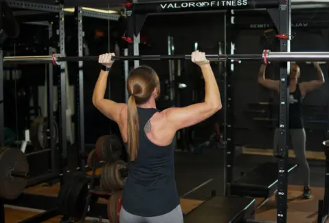 Katie Taylor, personal trainer with SPI performing an overhead press