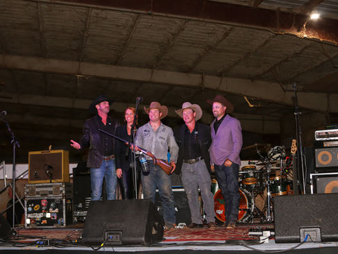 Diamonds & Denim Showdeo winner, Chad Rutherford, on stage receiving a shotgun for winning the showdeo 