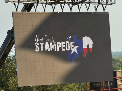 The Hood County Stampede logo on the big monitor screen at the Hood County Stampede rodeo at Reunion Grounds in Granbury