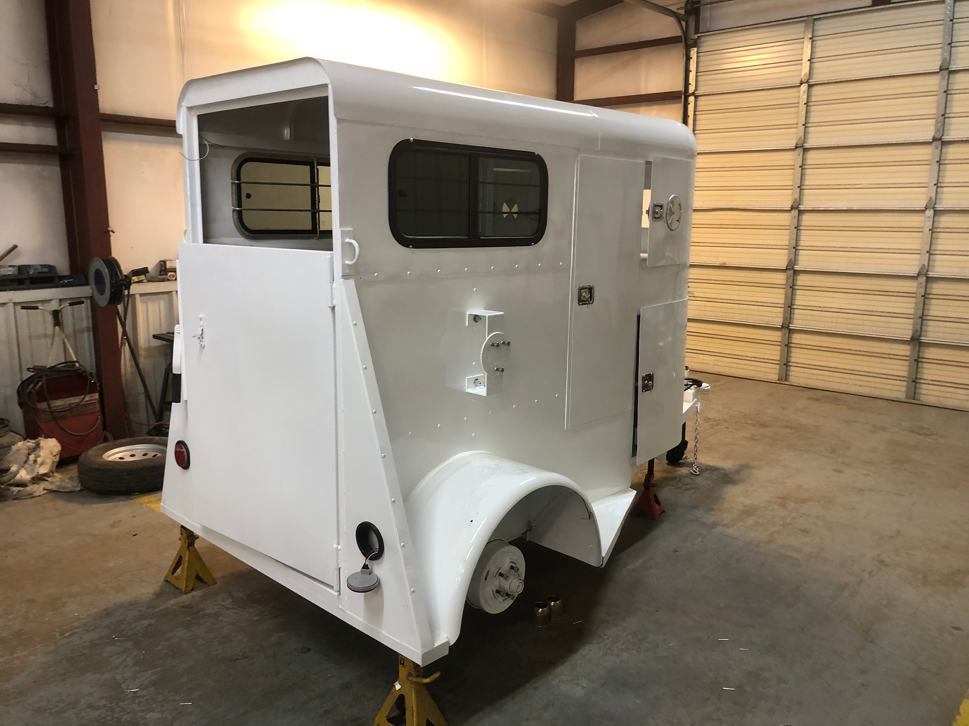 White vintage horse trailer inside the Dark Horse Metal Works welding shop in Granbury, TX