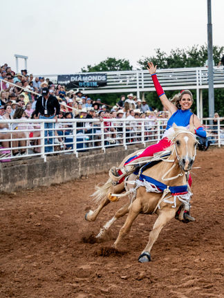 Summer Boyd, trick rider from Summer & Co. riding her horse in front of the sold out crowd at Reunion Grounds for the Hood County Stampede Charity Rodeo
