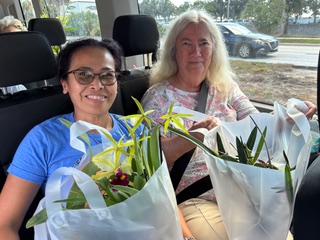 Two Tampa Orchid Club members with their orchid plants on the bus after the field trip