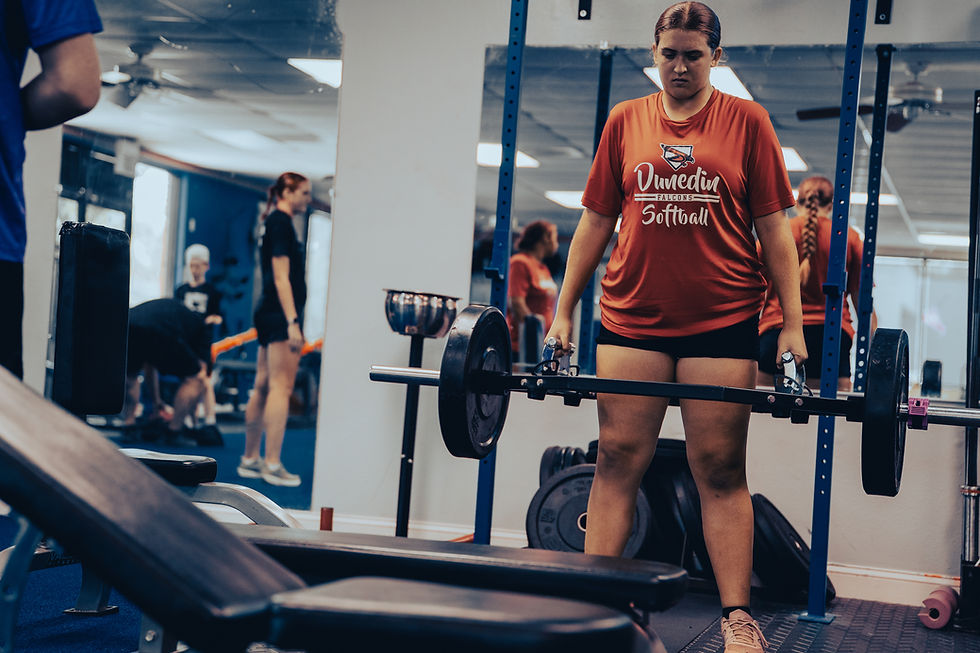 Softball girl training on the olympic squat bar during an athletic condition class at Strength & Performance Institute in Clearwater.