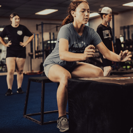 Student athletes doing box jumps at the Strength & Performance Institute gym in Clearwater