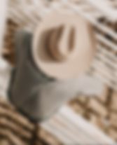 A cowboy hanging on the arena fence taken from above, the angle looks down on his hat