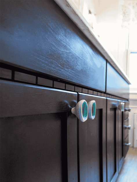 dark brown wood vanity close up with blue knobs