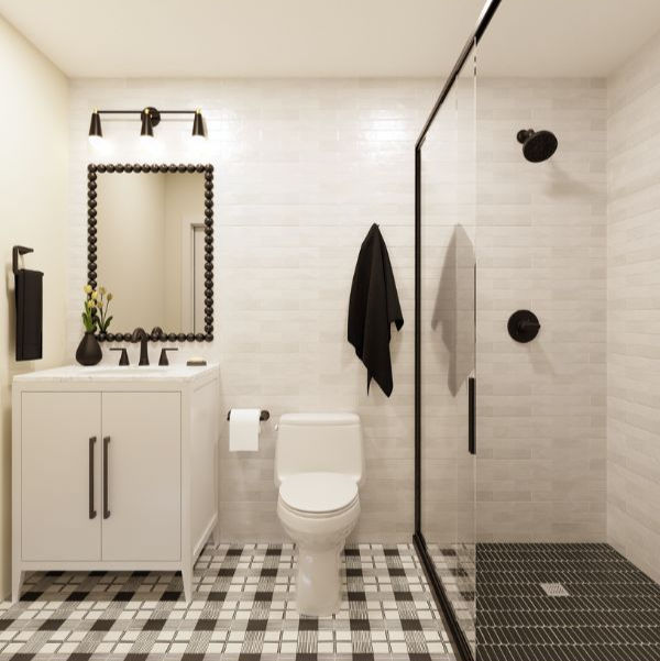 Modern bathroom with gray walls, twin mirrors, white towels, and flowers in a vase. Soft lighting creates a serene atmosphere.