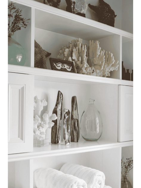 built in shelving with bottles and decor on shelves white bathroom