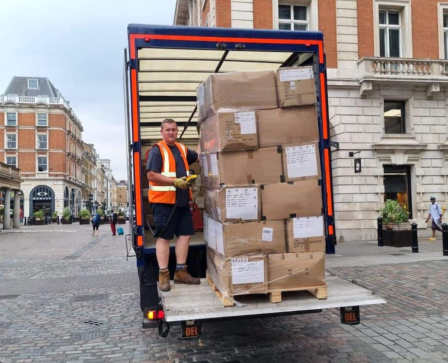 a man is standing next to a stacked parcel pallet