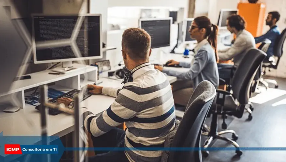 Equipe de TI trabalhando em escritório moderno com vários monitores; selo ICMP Consultoria em TI no canto inferior.