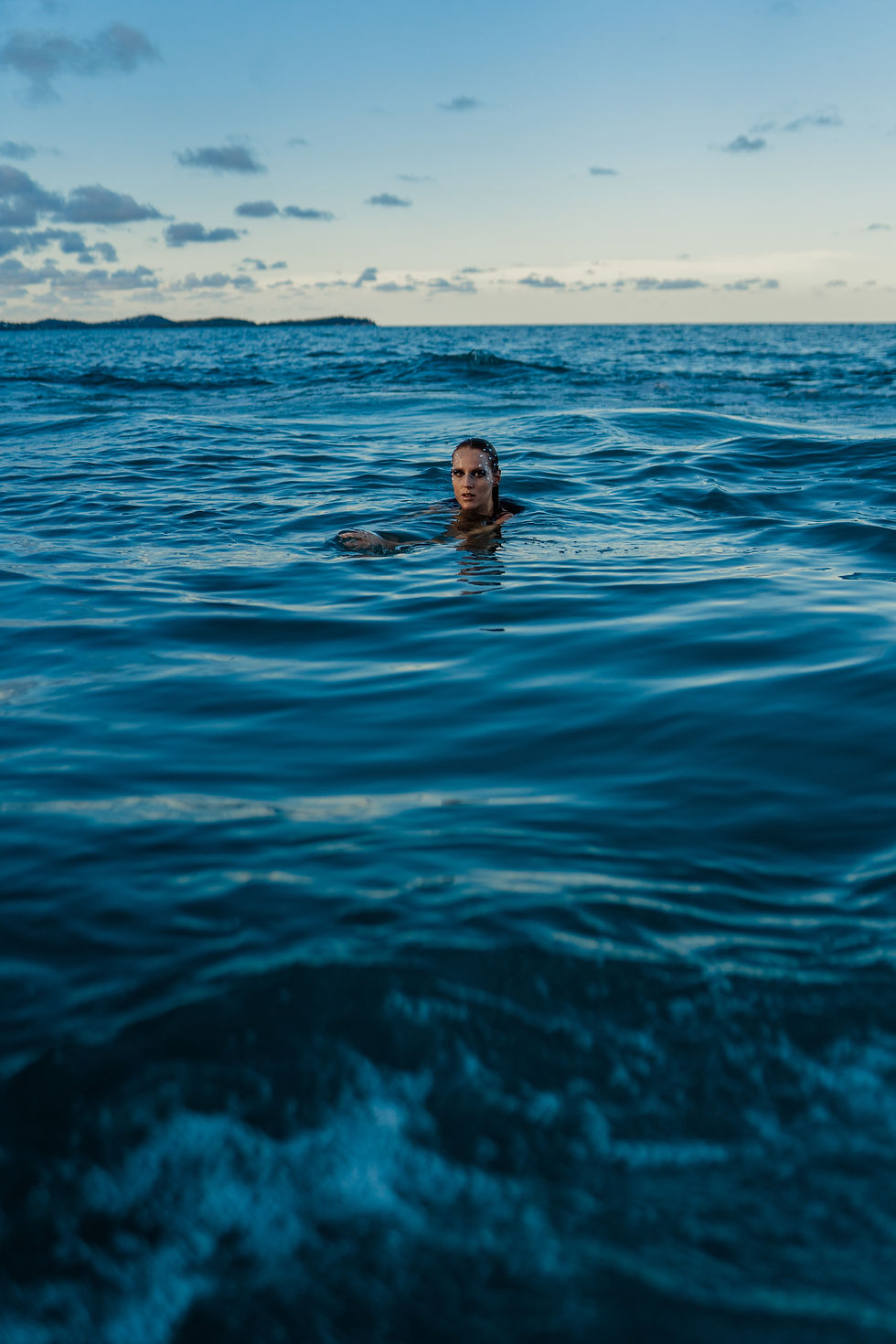 Woman swimming in dark blue ocean