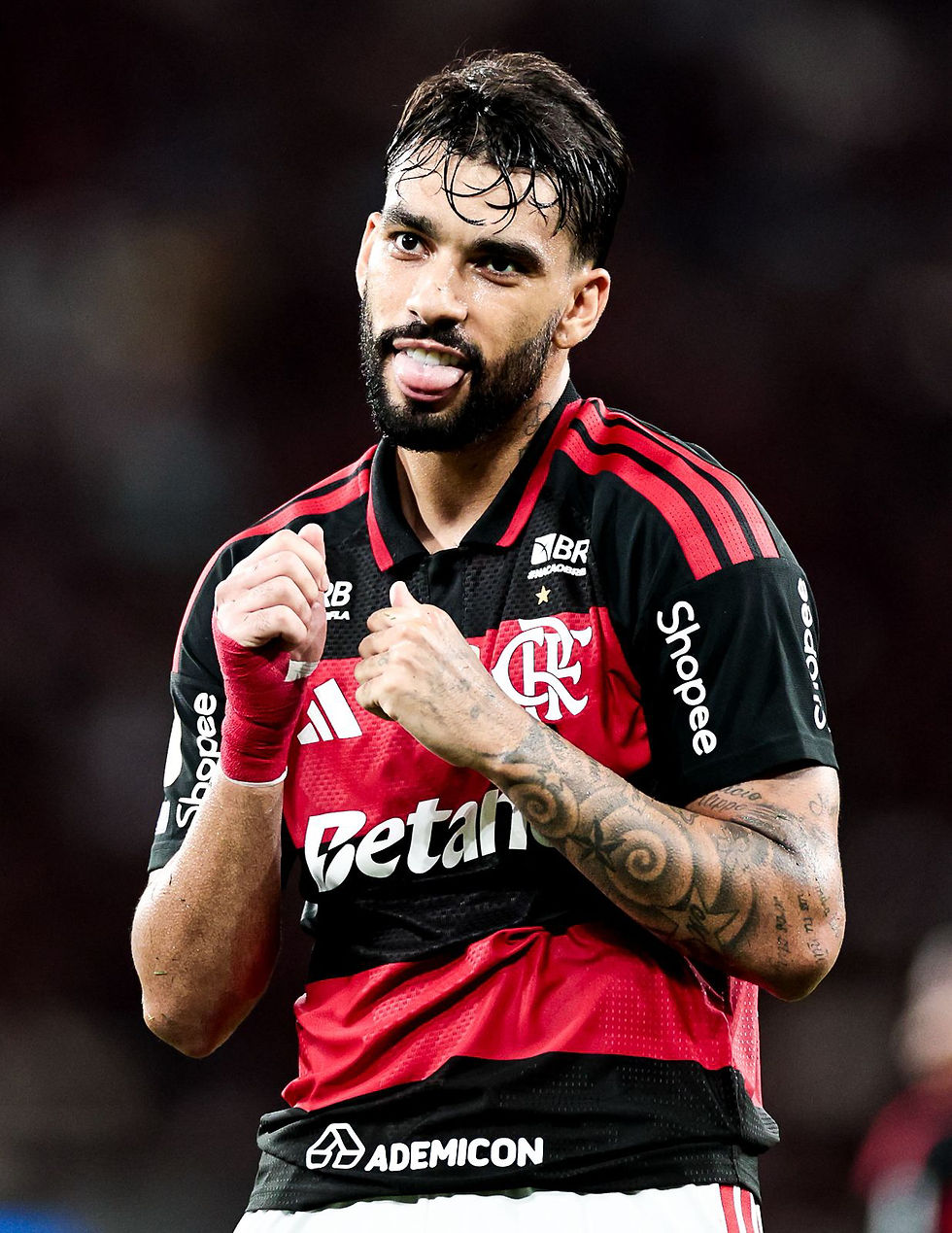 Jogador do Clube de Regatas do Flamengo comemora em campo com punhos cerrados e expressão intensa durante partida oficial.