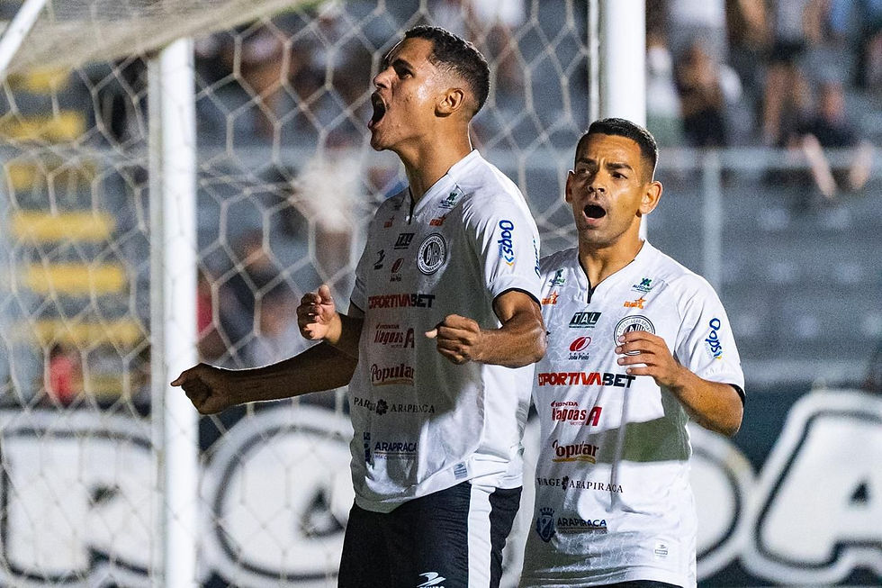 Jogadores do ASA de Arapiraca comemoram gol em frente à torcida durante partida noturna, com destaque para a vibração do atacante e o estádio ao fundo.