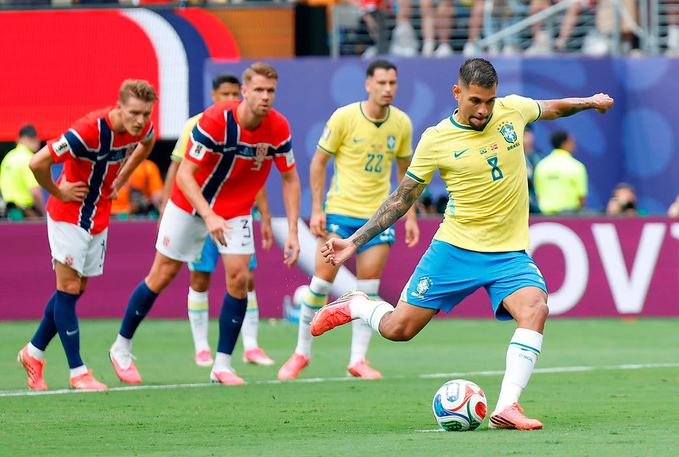 Jogador da Seleção Brasileira cobra um pênalti durante partida contra a Noruega pela Copa do Mundo FIFA 2026. O meio-campista veste a camisa amarela número 8 e finaliza com o pé direito, enquanto atletas noruegueses observam da entrada da área e companheiros brasileiros acompanham o lance ao fundo.