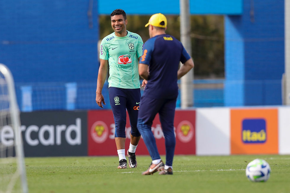 Jogador casemiro rir durante treino da seleção brasileira.