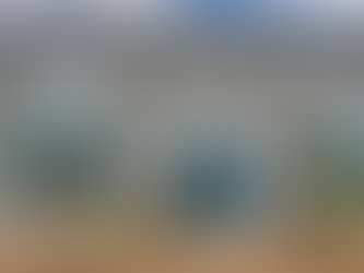 Front exterior of OliveUs Boutique in Frisco, Texas, featuring a gray brick building with blue double doors, large display windows, and seasonal decor.