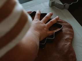 A child using a fall cookie cutter with homemade cinnamon playdough