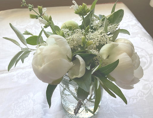Small floral centerpiece with white peonies and greens