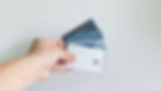 Individual holding a stack of credit cards spread out