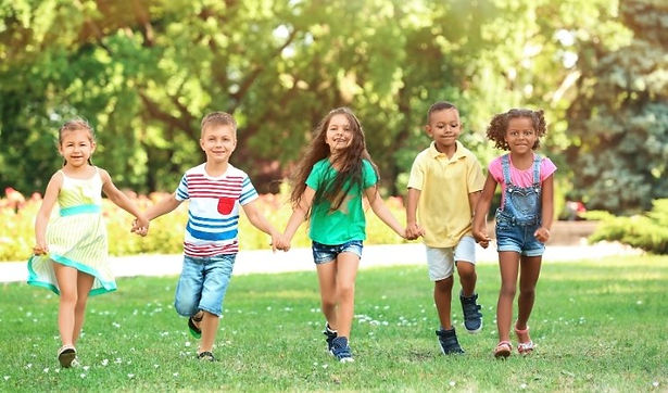 Bambini felici che corrono in un parco verde, simbolo di una città più vivibile, sicura e sostenibile grazie alla digitalizzazione della Pubblica Amministrazione e alla partecipazione civica.