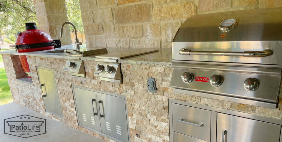 Custom outdoor kitchen with built-in Bull BBQ appliances, undermount sink, and Kamado Joe smoker in Round Rock, TX.