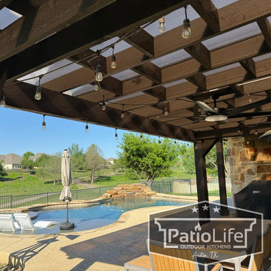 Custom cedar pergola with a staggered style ceiling, string lighting, and a polycarbonate roof in Teravista, Round Rock, TX.