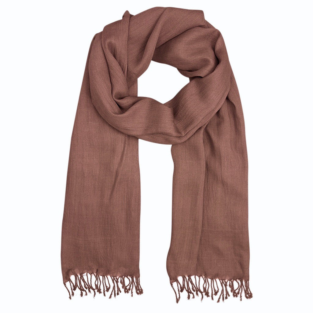 Brown scarf draped, featuring fringed edges for warmth and style. Khaam Fefalene.
