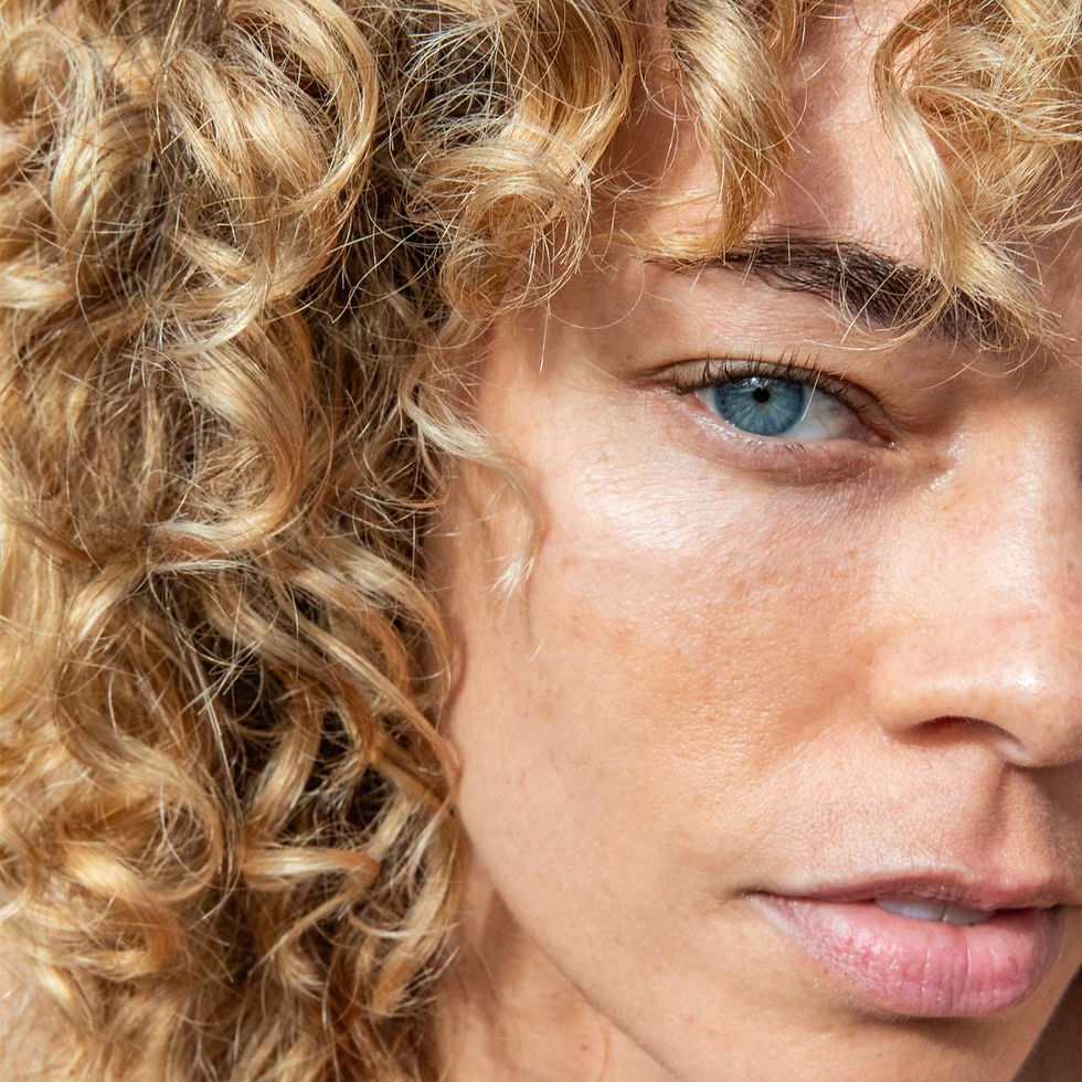 Close-up of a person with curly hair and blue eyes, Khaam Fefalene.