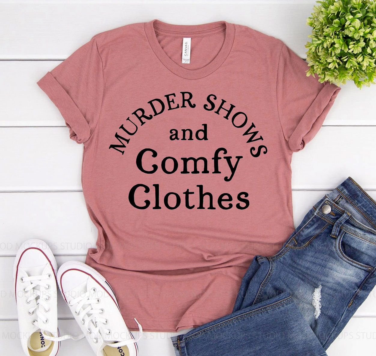 Pink t-shirt with text: Murder Shows and Comfy Clothes, and jeans.