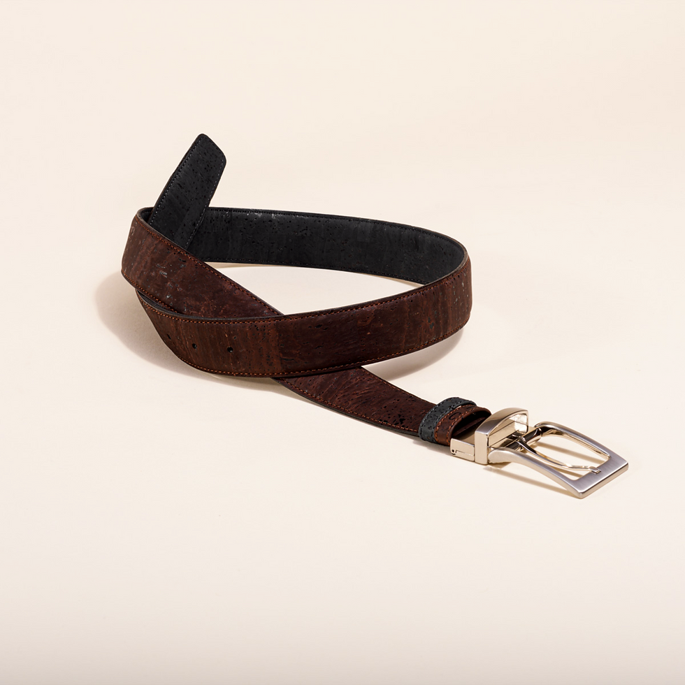 Brown belt with silver buckle on a cream backdrop, lifestyle shot.