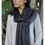 Thumbnail: Woman wearing a black scarf, paired with a white shirt and posing outdoors.