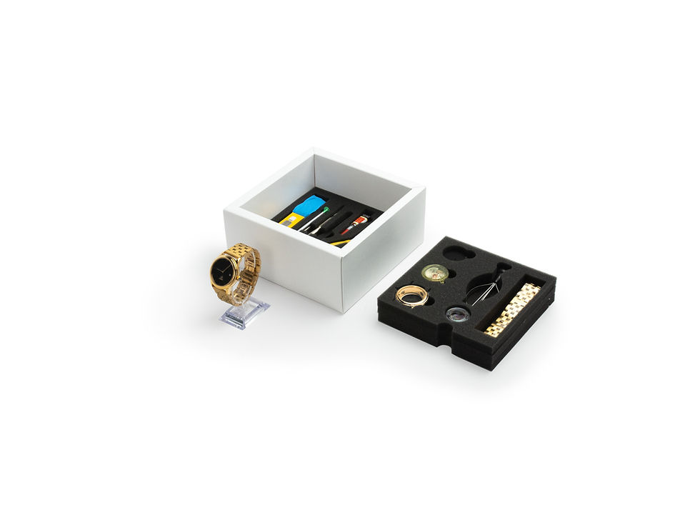 Golden ring on a stand next to an open box with accessories and Khaam Fefalene.