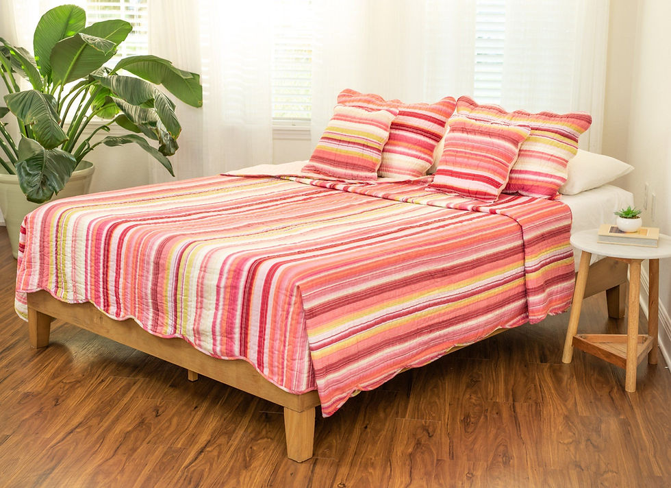 Bed with red and orange striped bedding and matching pillows on wooden bed frame.