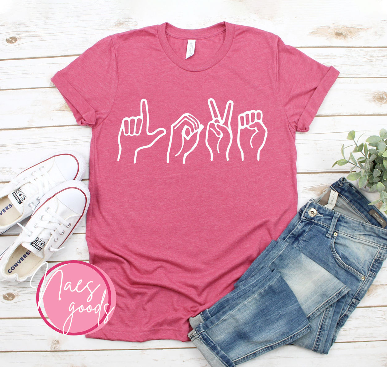 Pink T-shirt with white hands spelling LOVE; stylish jeans and shoes.