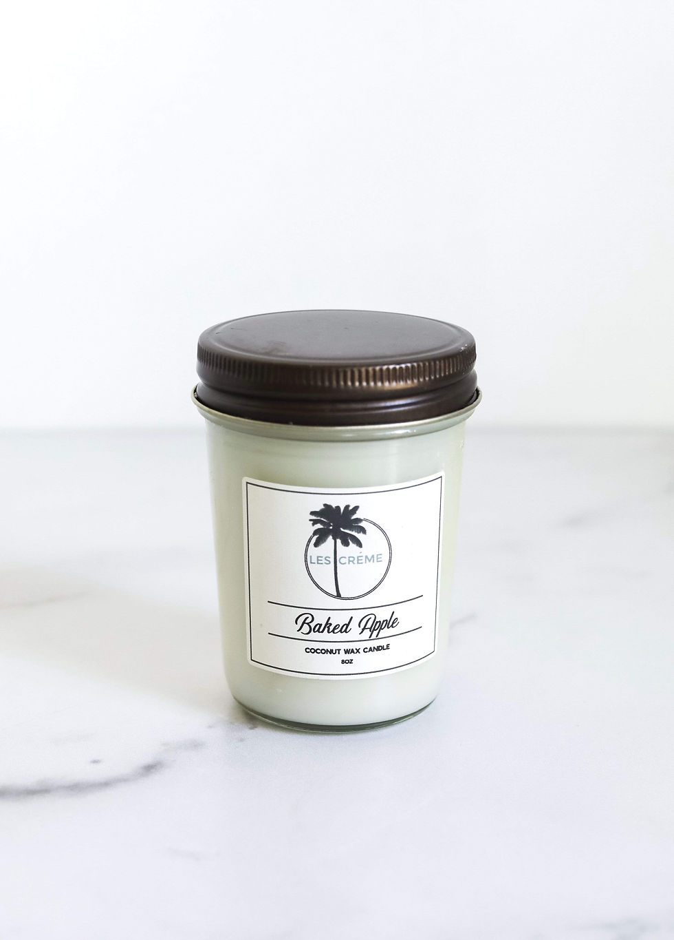 Candle with label, reads "Baked Apple". A scented candle for home decor.
