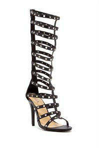 High heels black gladiator sandals with studs on white background. Khaam Fefalene.