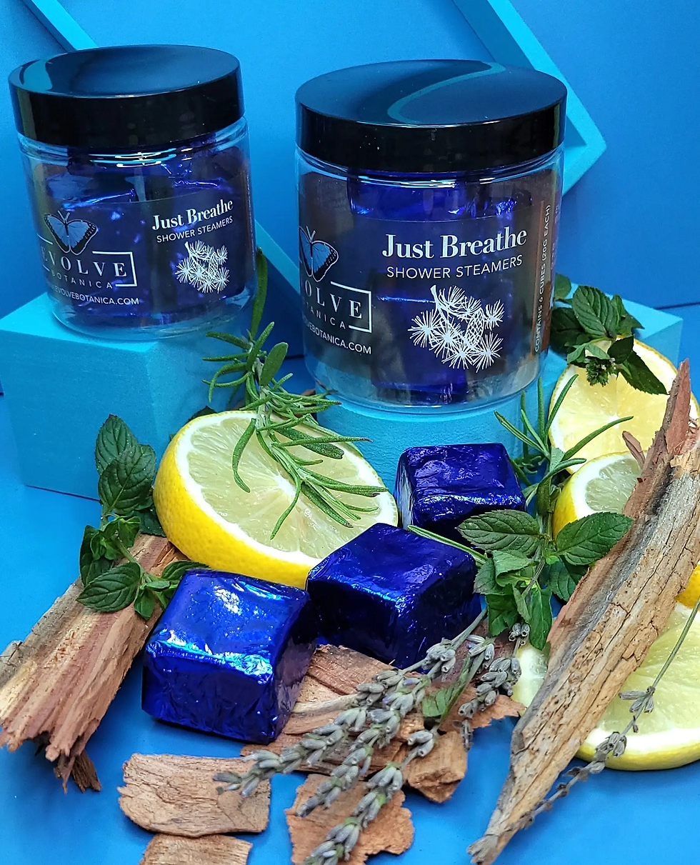 Two jars with the text Just Breathe and shower steamers with lemon slices.