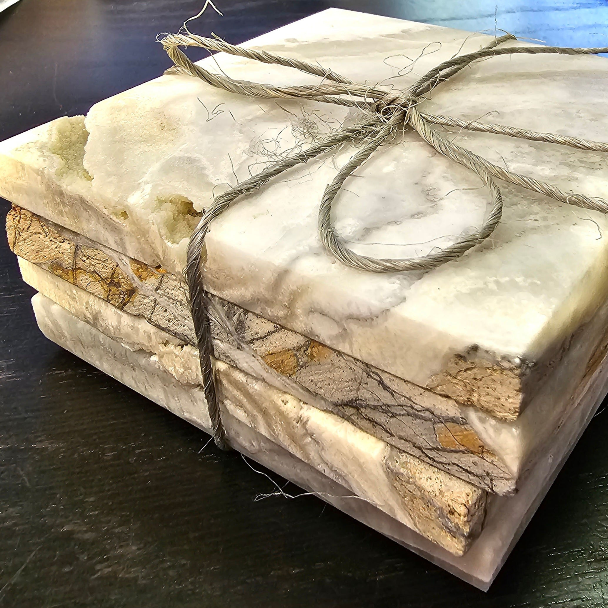 Stack of stone coasters tied with twine, perfect for home decor.