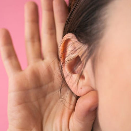 A woman cupping her ear with her hand, unilateral hearing loss, causes, and treatments at Topeka ENT.