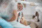 senior man sitting in dental chair at the dentist and smiling