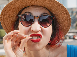woman using a toothpick to clean food stuck between her teeth
